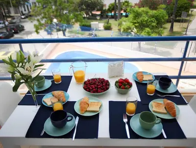 a table with breakfast foods and drinks on a balcony at Atlantic Pearl by the Sea - Quarteira in Quarteira