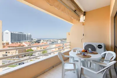 a balcony with a table and chairs and a microwave at MILA - Vilamoura in Vilamoura