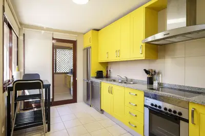 a yellow kitchen with yellow cabinets and a counter at BmyGuest - Vilamoura Vila Sol Golf II in Vilamoura