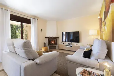 a living room with two white chairs and a television at BmyGuest - Vilamoura Vila Sol Golf II in Vilamoura
