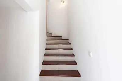 a staircase in a house with white walls and wooden floors at Villa Eskape in Albufeira