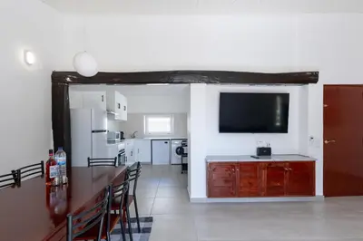 a living room with a television and a kitchen at Villa Eskape in Albufeira