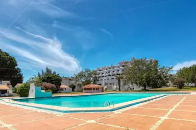 a swimming pool with a building in the background at Villa Eskape in Albufeira