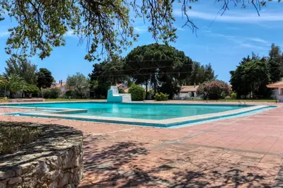 a swimming pool in a villa with trees in the background at Villa Eskape in Albufeira