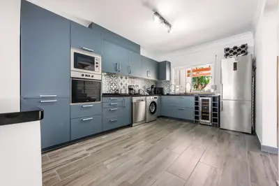 a kitchen with blue cabinets and stainless steel appliances at Casa Merrigan in Albufeira