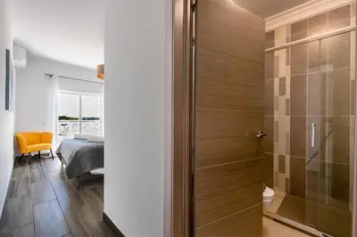 a bathroom with a shower and a bedroom at Casa Merrigan in Albufeira
