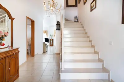 a staircase in a home with white walls and a chandelier at Villa Magdalena in Albufeira