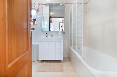 a bathroom with a sink and a tub and a mirror at Villa Magdalena in Albufeira