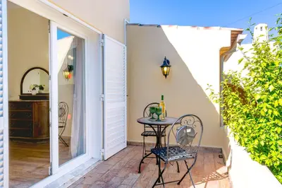 a patio with a table and chairs next to a swimming pool at Villa Pinheiro in Albufeira