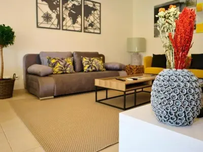 a living room with a couch and a vase with flowers at White 47 House by Stay ici Algarve Holiday Rental in Albufeira