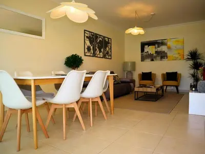 a dining room and living room with a table and chairs at White 47 House by Stay ici Algarve Holiday Rental in Albufeira