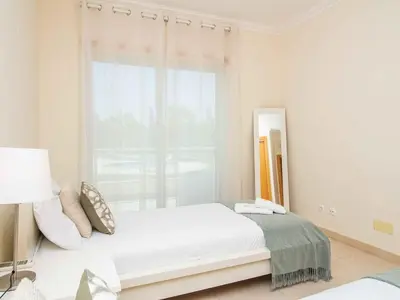 a white bedroom with a bed and a window at White 47 House by Stay ici Algarve Holiday Rental in Albufeira