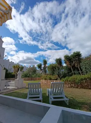 two white chairs sitting on the grass in a yard at Albufeira - Sun, Pool and Marina View! in Albufeira
