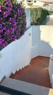 a staircase with purple flowers on a white wall at Albufeira - Sun, Pool and Marina View! in Albufeira