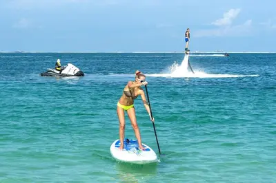 a woman in a bikini on a paddle board in the ocean at Maison avec piscine et jacuzzi in Guia