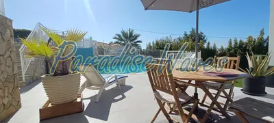 a patio with a table and chairs and an umbrella at Maison avec piscine et jacuzzi in Guia