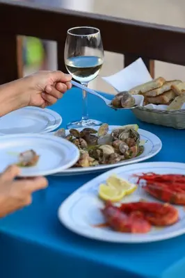 a plate of food with tomatoes and other foods on a table at Maria Luisa Beach -Amaral's Guesthouses in Albufeira