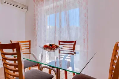 a glass dining room table with chairs and a bowl of fruit at Spacious 2 bedroom apartment in Faro in Faro