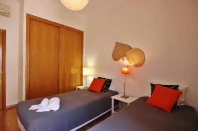 two beds in a room with red and white pillows at Los Arcos 3 - Pool & Vilamoura Center in Vilamoura