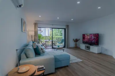 a living room with a couch and a tv at Beachside Bliss T2 with Pool & Beach Access by Drago Rentals in Albufeira