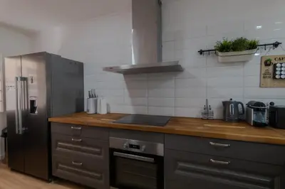 a kitchen with a stainless steel refrigerator and wooden counter top at Beachside Bliss T2 with Pool & Beach Access by Drago Rentals in Albufeira