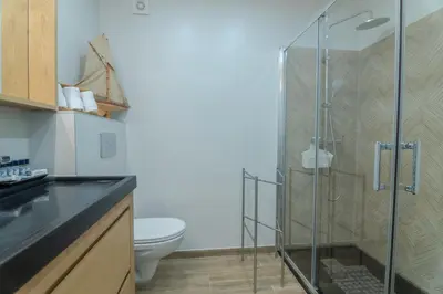a bathroom with a glass shower with a toilet at Beachside Bliss T2 with Pool & Beach Access by Drago Rentals in Albufeira