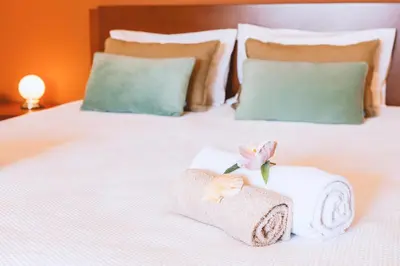 a white bed with towels and a flower on it at Villa Maya Bay by Algarve Vacation in Guia