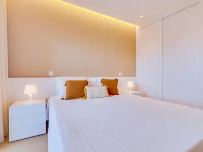 a bedroom with a large white bed with two lamps at AL - Apartamento Novo Horizonte in Vilamoura