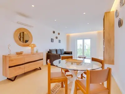 a dining room and living room with a table and chairs at AL - Apartamento Novo Horizonte in Vilamoura