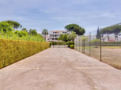 a driveway with a fence and a tennis court at AL - Apartamento Novo Horizonte in Vilamoura