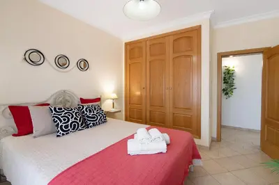 a bedroom with a white bed with towels on it at J R Dream house in Quarteira