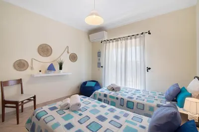 a bedroom with two beds and a bathroom at J R Dream house in Quarteira