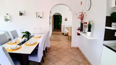 a patio with chairs and an umbrella on a balcony at J R Dream house in Quarteira