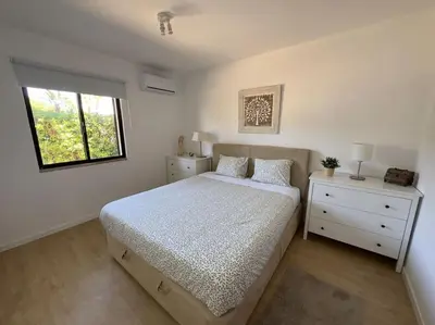 a white bedroom with a bed and a window at Balaia Golf Village apt 105 in Albufeira