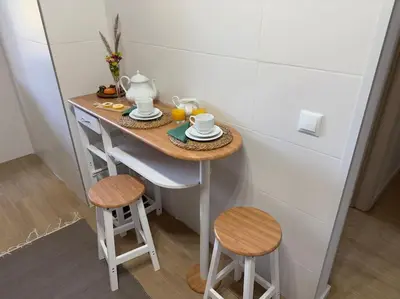 a small table with two stools and a tea set on it at Balaia Golf Village apt 105 in Albufeira