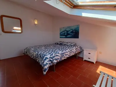 a small bedroom with a bed and a mirror at Apartamento Praia da Gale in Albufeira