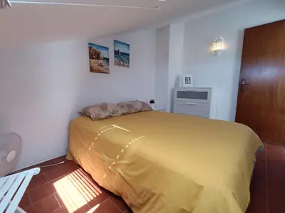 a bedroom with a yellow bed in a room at Apartamento Praia da Gale in Albufeira