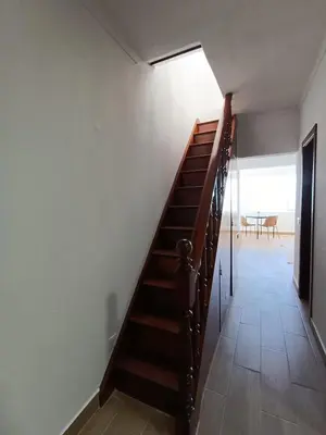 a staircase in a room with a table and chairs at Apartamento Praia da Gale in Albufeira