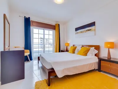 a bedroom with a large bed and a window at Central 2bdr apartment in Quarteira in Quarteira