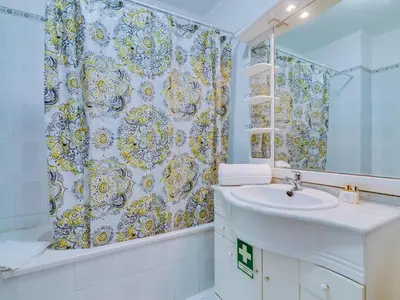 a bathroom with a sink and a shower curtain at Central 2bdr apartment in Quarteira in Quarteira