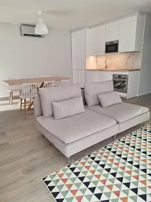 a living room with a couch and a kitchen at Apartment Center View in Faro