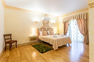a bedroom with a bed and a table and a chair at Exceptional Villa with Pool, Tennis Court, Games Room in Quarteira