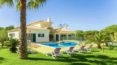 a villa with a swimming pool and lounge chairs at Exceptional Villa with Pool, Tennis Court, Games Room in Quarteira