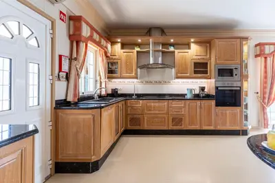 a kitchen with wooden cabinets and a sink at Exceptional Villa with Pool, Tennis Court, Games Room in Quarteira