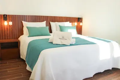 a bedroom with a large bed with white and green sheets at Monte do Couto in Albufeira