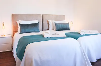 two beds with white and blue sheets in a room at Monte do Couto in Albufeira