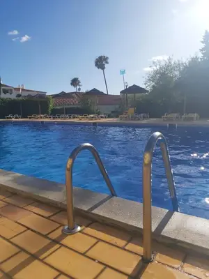 a swimming pool with a metal railing next to it at Sea Turtle Apartment - Albufeira in Albufeira