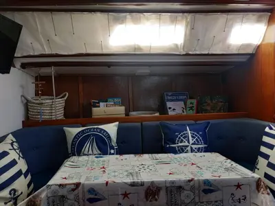 a bed in a room with a blue couch with pillows at Houseboat - Faro in Ria Formosa in Faro