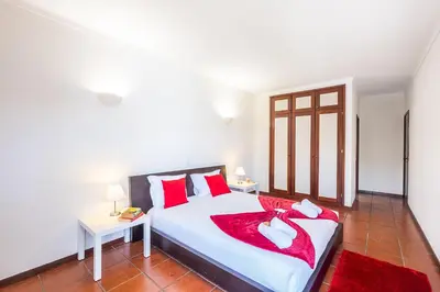 a bedroom with a large white bed with red pillows at Villa Saint Lucia by Algarve Vacation in Albufeira