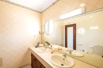 a bathroom with two sinks and a large mirror at Villa Saint Lucia by Algarve Vacation in Albufeira